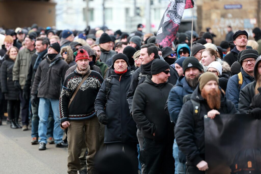 Wilhelm Tell läuft als Teilnehmer bei "Trauermarsch" am 15.02.2025 in Dresden. Unter den Teilnehmenden sind u.a. Patrick Weber (Heimat) und Nikolai Nerling ("Volkslehrer") zu sehen.