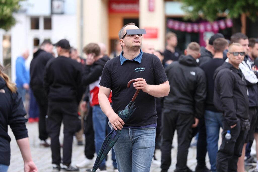 Foto aus Apolda auf dem Simon Ehrenreich auf dem Markt zu sehen ist. Er trägt eine Brille bei der ein schwarzer Balken seine Augen verdeckt.