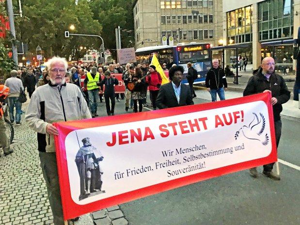 Foto von Timo Richter vom 26.09.2022 in Jena. Zusammen mit Jens Thino Friedrich trägt Richter ein rotes Transparent, auf dem steht: „Jena steht auf! Wir Menschen für Frieden, Freiheit, Selbstbestimmung und Souveränität!