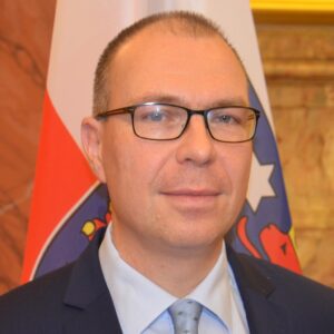 Porträtbild von Stefan Gerber, der vor einer Thüringen Fahne steht.