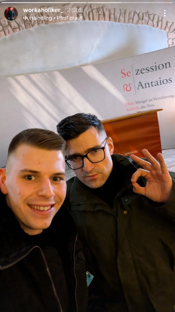Selfie von Noah Malsch mit dunkler Kurzhaar-Scheitelfrisur und Martin Sellner, der das „White Power“-Zeichen macht. Im Hintergrund sieht man die Schriftzüge der „Sezession“. 